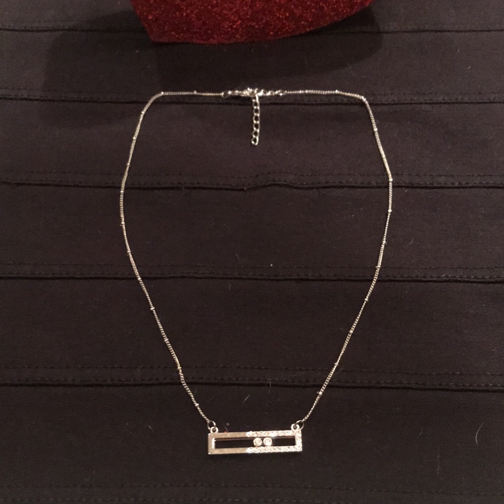 Silver tone necklace with 2 moving crystals.